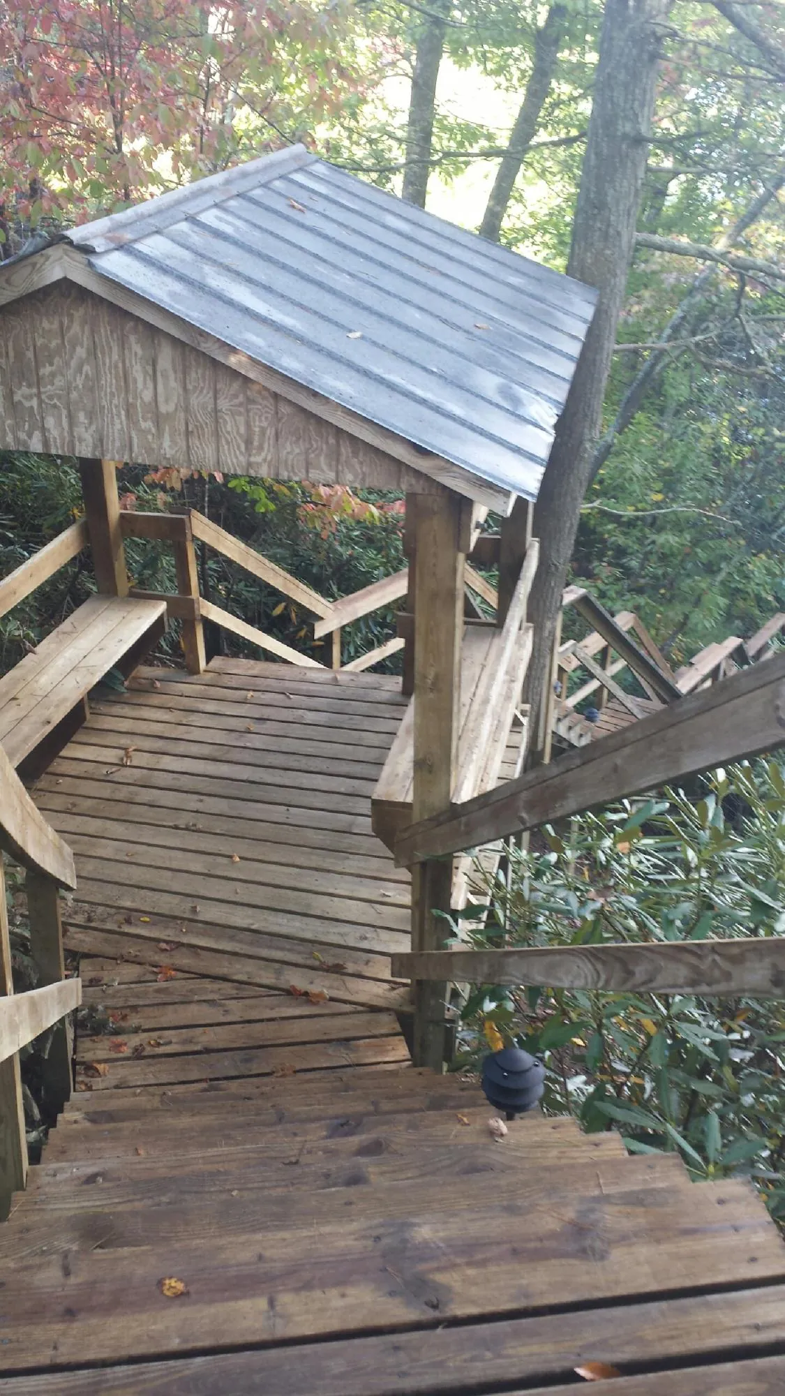 Metal roofed shelter over wooden steps on a wooded walkway — Skylight Repair & Installation work by our crew in Kevil