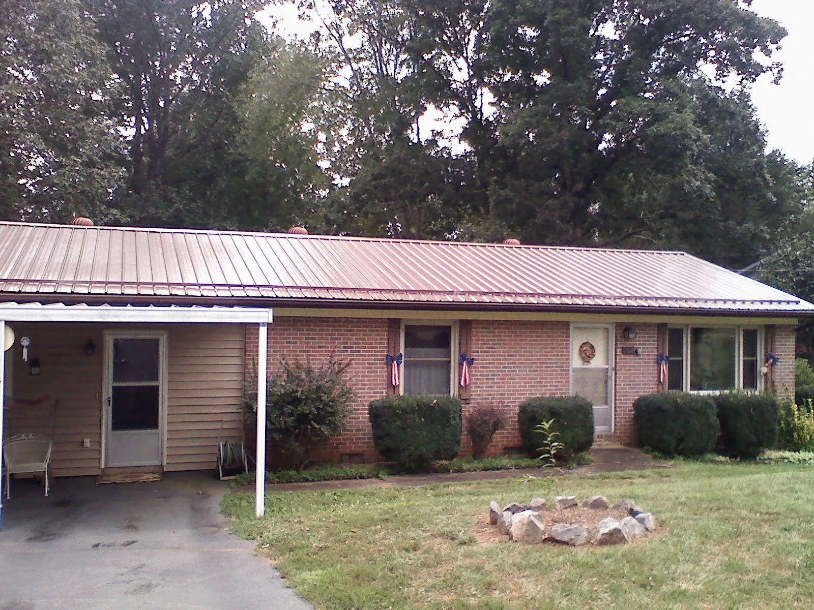 Bronze metal roof and carport on a brick ranch home — Roof Repair work by our crew in Kevil